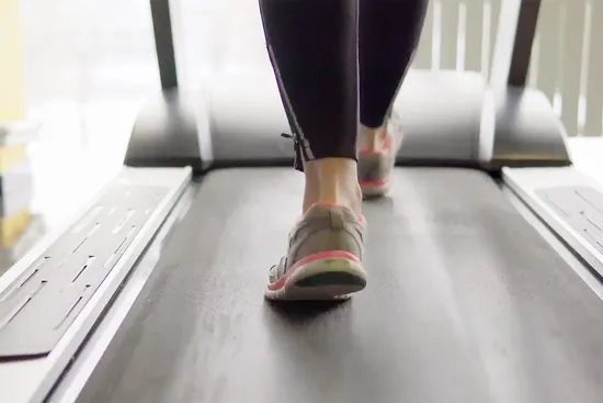 photo of woman walking on treadmill